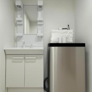 a white bathroom with a sink and a mirror at TOEI BUSSAN Building20 in Osaka