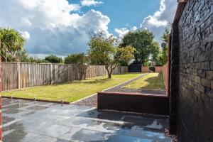 un patio con una valla y un patio en Where Style Meets Comfort The New Forest Home, en Southampton