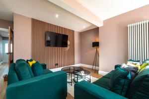 Una sala de estar con dos sofás azules y un televisor. en Where Style Meets Comfort The New Forest Home, en Southampton