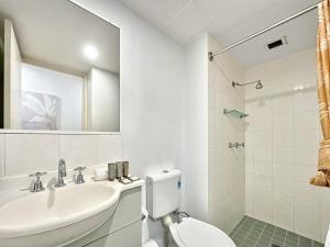 Un baño blanco con lavabo e inodoro. en Brisbane Apt Near Dining Shops and River Walks, en Brisbane 14 fotos más