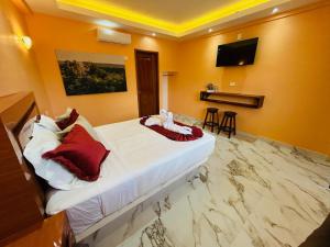 ein Hotelzimmer mit Bett und Flachbildfernseher in der Unterkunft Hotel Hormiguero in Xpujil