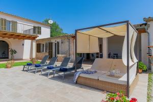 patio con sedie a sdraio e ombrellone di Villa Sera de Caimari By home villas 360 a Caimari