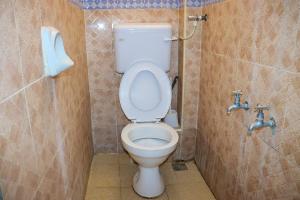 Un baño con un inodoro blanco en una cabina. en Little escalade, en Mombasa