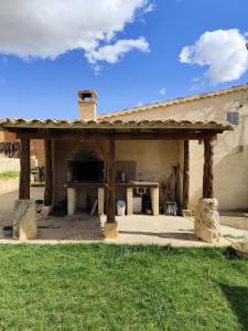 a pavilion with a table in front of a building at Casa Rural La Charolesa in Aguilera