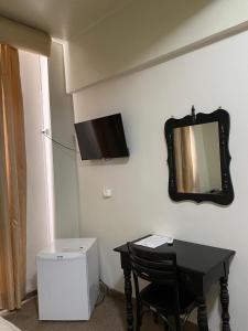 a room with a table and a mirror on the wall at Hotel Ponta Grossa São Marcos in Ponta Grossa