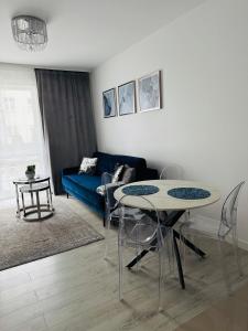 a living room with two tables and a blue couch at LUX Apartament in Suwałki
