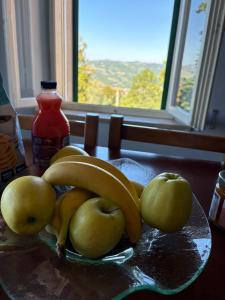 a plate of bananas and apples on a table with a window at La Loggia dei Fabbri - Montefabbri in Monte Fabbri