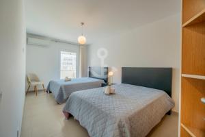 a bedroom with two beds and a tv in it at Novo T1 com piscina - Descobrir O Mar 5 in Armação de Pêra +29 photos