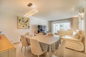 a living room with a dining room table and a couch at Novo T1 com piscina - Descobrir O Mar 5 in Armação de Pêra