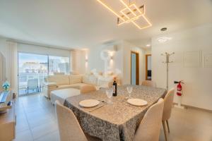 a dining room and living room with a table and chairs at Novo T1 com piscina - Descobrir O Mar 5 in Armação de Pêra