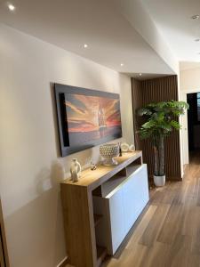 a living room with a television on a wall at SICILIA FIERA Apartment in Misterbianco