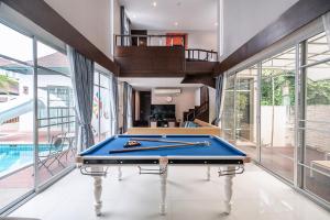 a pool table in a room with windows and a staircase at Sorrento Pool Villa Naga Jomtien Pattaya in Na Jomtien