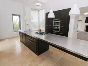 cocina con encimera negra y fogones en Sruthan Lodge, en Cornamucklagh South
