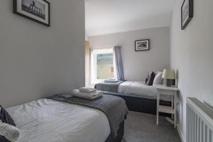a bedroom with two beds and a window at Chestnut House - Sleeps 4 - Pet friendly -Parking in Ashington