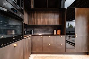 une cuisine avec des armoires en acier inoxydable et une cuisinière dans l'établissement Villa Komia Iso by Aavalevi, à Levi 38 autres photos