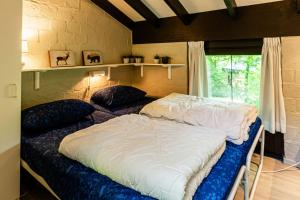 a bedroom with two beds and a window at Domaine le Boulac - Holiday park Durbuy in Durbuy +48 photos