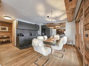 a dining room with white chairs and a table at Standing Megeve - 2 to 8 people - Mont d'Arbois in Megève