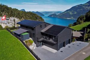 an aerial view of a black house with a lake at Villa Tauris in Emmetten