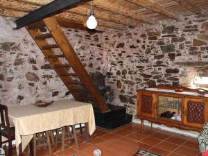 a dining room with a table and a stone wall at Casa do Moinho Novo in Fontão Fundeiro +45 photos