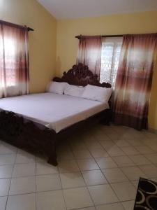 Cama grande en habitación con cortinas en Luxury 3 Bedroom Home Mtwapa, en Mtwapa 12 fotos más