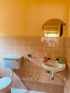 Un baño con lavabo, inodoro y espejo. en Luxury 3 Bedroom Home Mtwapa, en Mtwapa