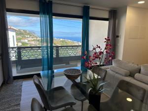 a living room with a couch and a large window at Madeira Inn Refúgio Ponta do Sol in Ponta do Sol