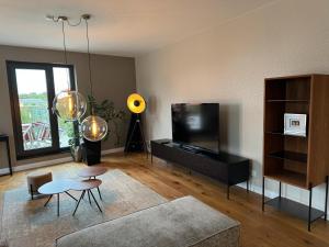 a living room with a couch and a tv at 180qm Penthouse mit Sonnenterrasse in Rostock +36 photos