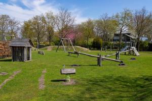 a park with a swing set and a playground at Mosselbank 073 - Noordzeepark Ouddorp in Ouddorp