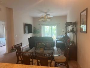 un soggiorno con tavolo e sedie in vetro di Disney Area Vacation Kissimmee a Kissimmee