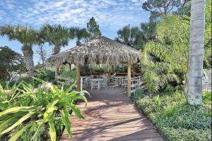 un tavolo e delle sedie sotto un ombrellone di paglia di Disney Area Vacation Kissimmee a Kissimmee