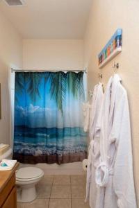 un bagno con doccia e tenda da doccia a forma di palma di Disney Area Vacation Kissimmee a Kissimmee