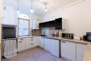a kitchen with white cabinets and a counter top at Appartement Central et Fonctionnel in Sarlat-la-Canéda +11 photos