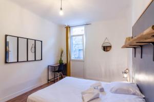 a bedroom with a white bed and a window at Appartement Central et Fonctionnel in Sarlat-la-Canéda