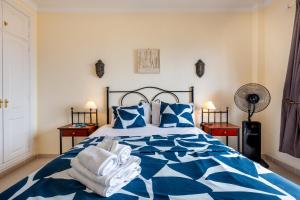 a bedroom with a blue and white bed with towels on it at Tranquilidad frente al mar by CABANA Rentals in Arona +15 photos