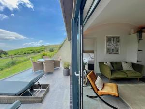 a room with a balcony with a couch and a table at The Willow Hill in Aberdyfi