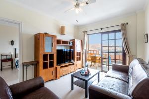 a living room with a couch and a tv at Tranquilidad frente al mar by CABANA Rentals in Arona