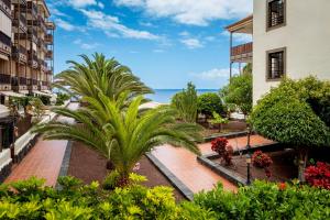 a view from the balcony of a building with a palm tree at Tranquilidad frente al mar by CABANA Rentals in Arona