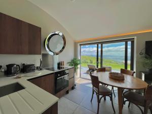 a kitchen and dining room with a table and a window at The Willow Hill in Aberdyfi