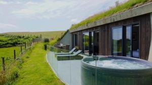 a house with a hot tub on the side of it at The Willow Hill in Aberdyfi +6 photos