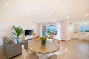 un soggiorno con un tavolo e un divano di The Oceanfront Studio Luz VR110 a Luz