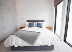 una camera da letto con un letto grande con cuscini blu di 2-Bed Townhouse with Garden and Private Parking in D04 a Dublino Altre 10 foto