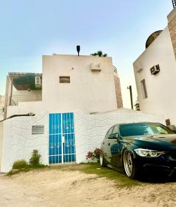 ファイドにあるVilla Kayan in fayedの青いドア付きの建物の前に停車する車