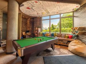 a billiard room with a pool table and a couch at Ibis Warszawa Ostrobramska in Warsaw