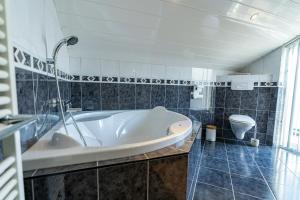 a bathroom with a tub and a toilet at Veermansplaat 27 - Noordzeepark Ouddorp in Ouddorp +38 photos