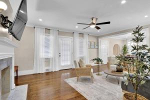 a living room with a fireplace and a ceiling fan at Sleek 5br Buckhead Homemodern,spacious & Central in Atlanta