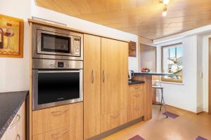 a kitchen with wooden cabinets and a microwave at Ferienwohnung Hewenpanorama 1 in Engen