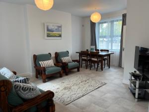 ein Wohnzimmer mit Tisch und Stühlen und ein Esszimmer in der Unterkunft Sunberry 2 Bright Modern Entire Home, Headford in Headford