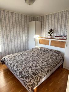 a bedroom with a bed and a wall at Stunning lakeside home with sauna surrounded by nature in Sandared