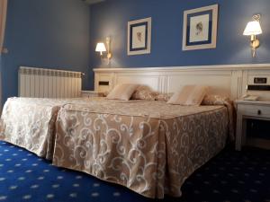 Un dormitorio con una cama en una habitación azul. en Hotel Leonor Mirón, en Soria