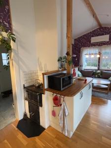 a kitchen with a microwave on top of a counter at Stunning lakeside home with sauna surrounded by nature in Sandared +33 photos